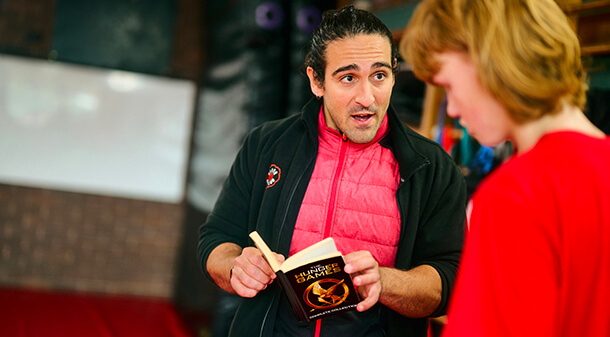 A teacher reading a book with a student