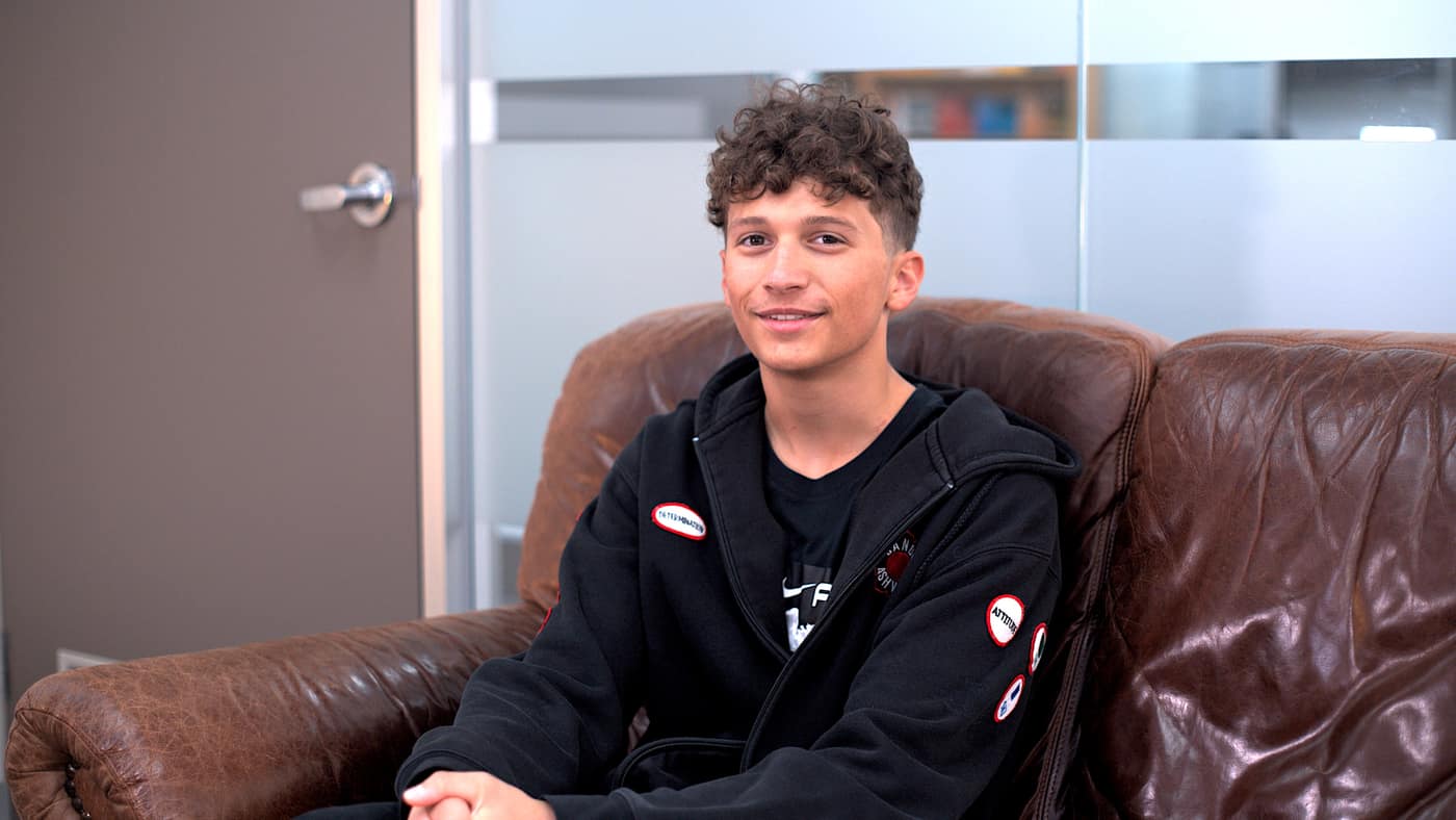 A smiling FDSA student sitting on a leather couch